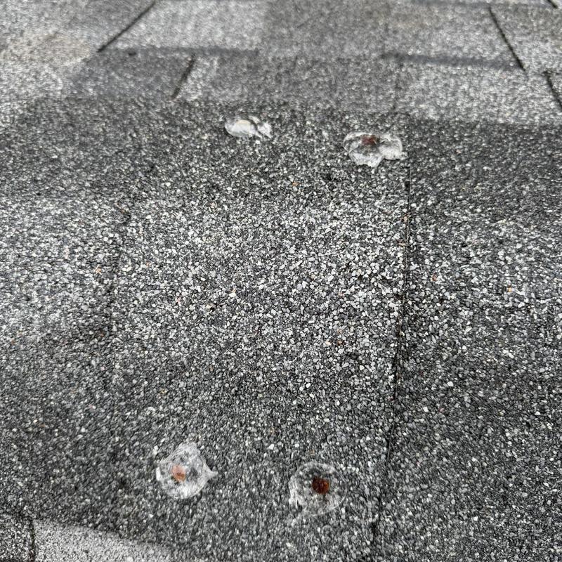 Exposed ridge cap nails sealed on roof shingles