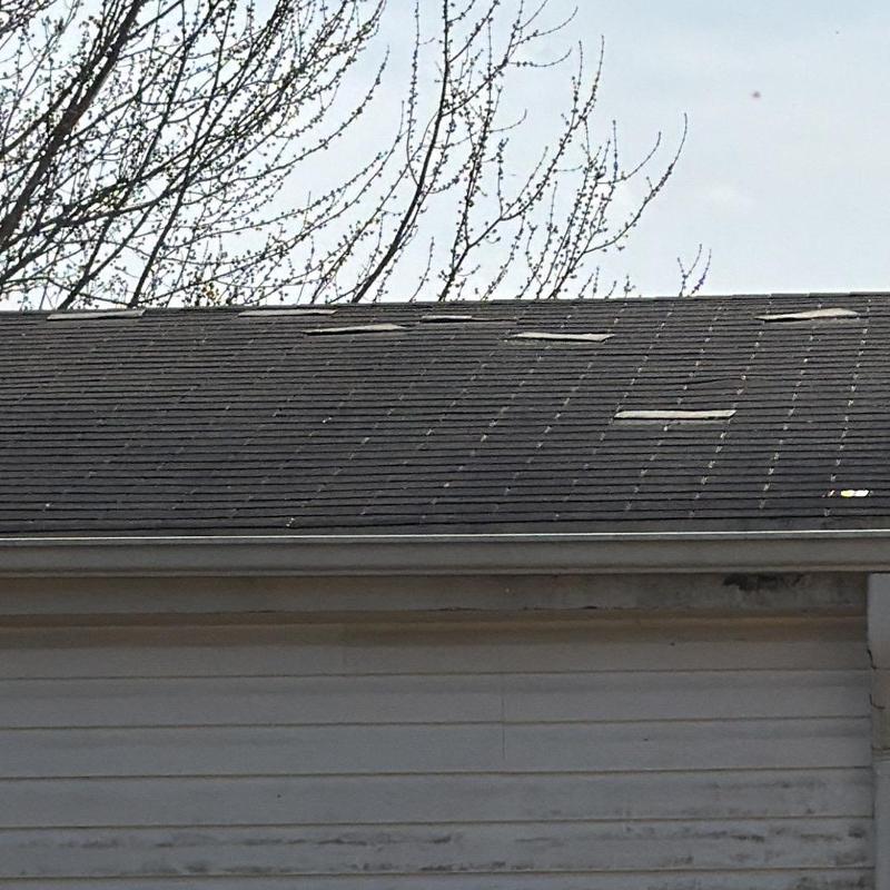 Damaged roof shingles with weather wear and tear