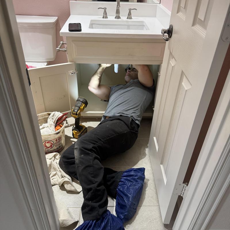 Bathroom sink drain pipe inspection under vanity