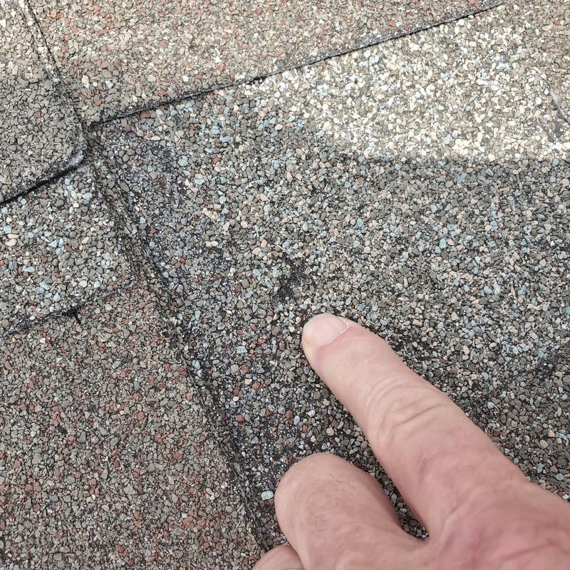 Asphalt shingle roof showing hail damage close-up