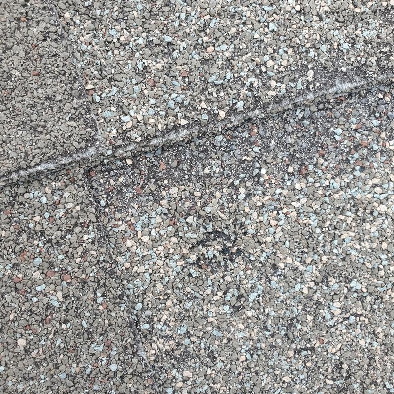 Asphalt shingle granule loss from hail damage close-up