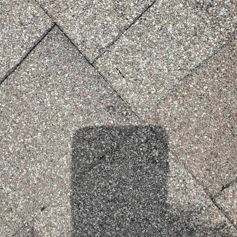 Asphalt roof shingles with hail damage close-up