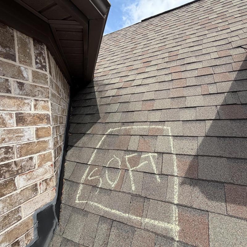 Roof shingles with soft spot marked for repair