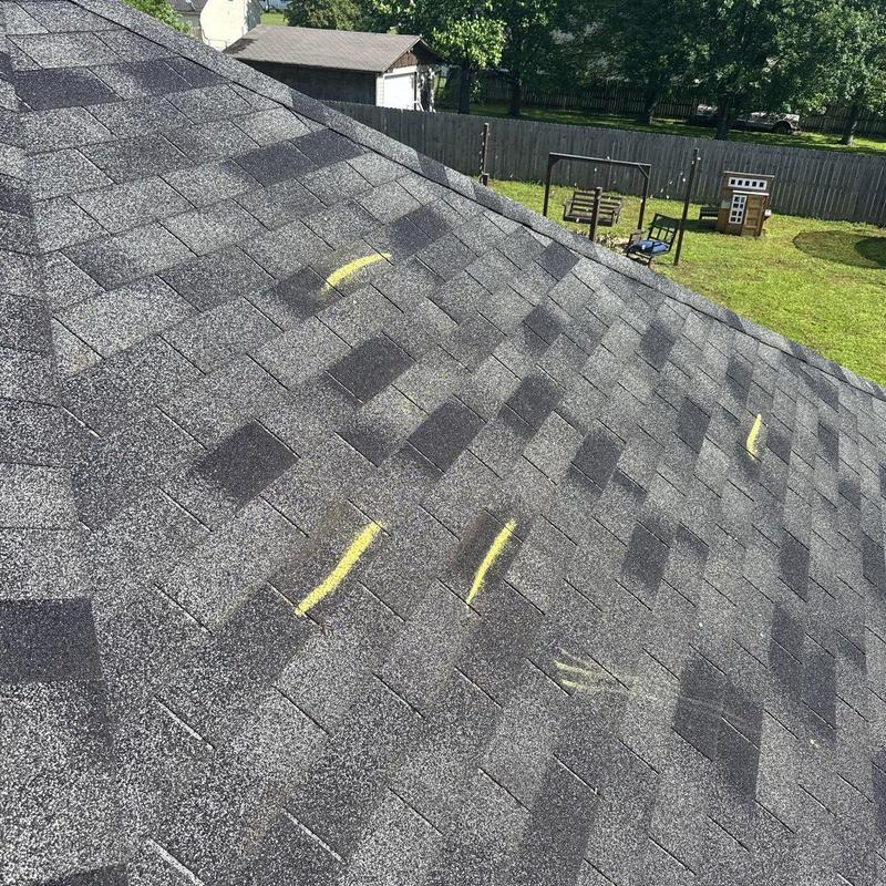 Asphalt shingles with hail damage marked for inspection