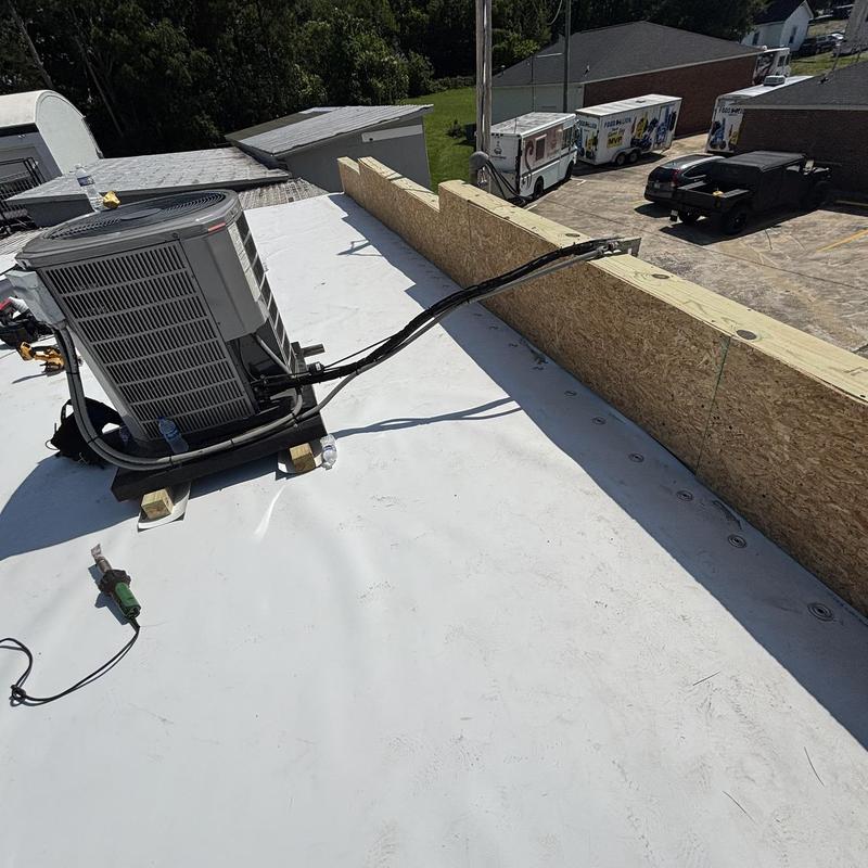 TPO flat roof with HVAC unit and new wood wall barrier TPO flat roof with HVAC unit and new wood wall barrier