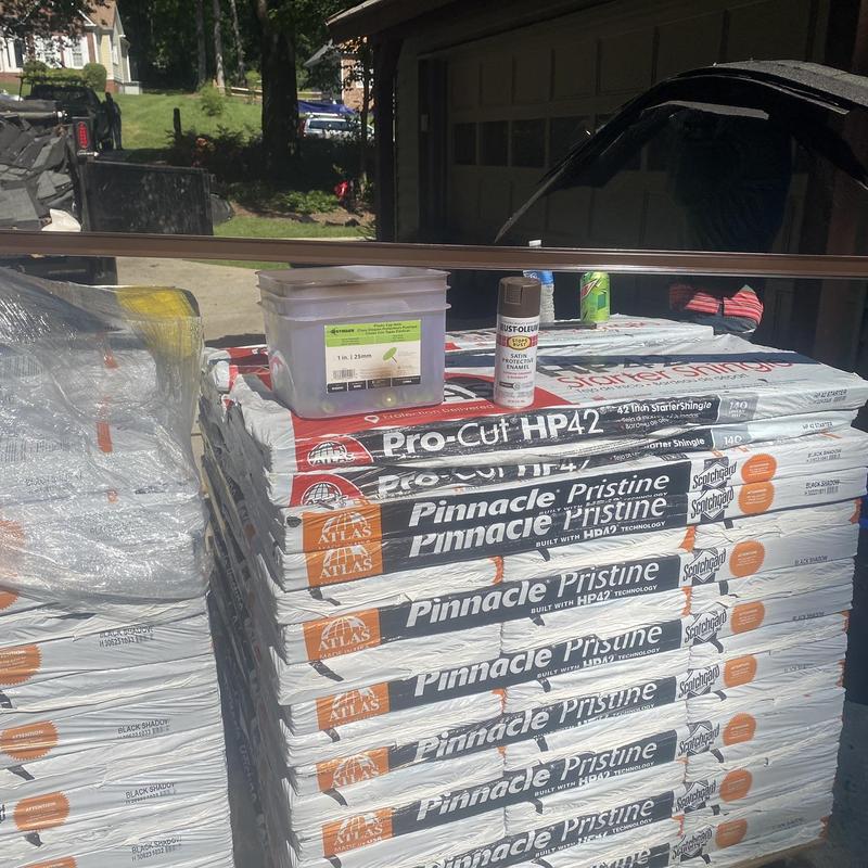 Atlas Pinnacle Pristine roofing shingles stacked outdoors Atlas Pinnacle Pristine roofing shingles stacked outdoors