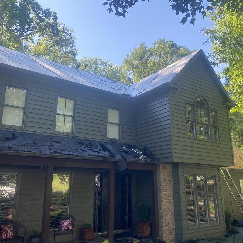 Roofing with torn shingles during storm damage removal Roofing with torn shingles during storm damage removal