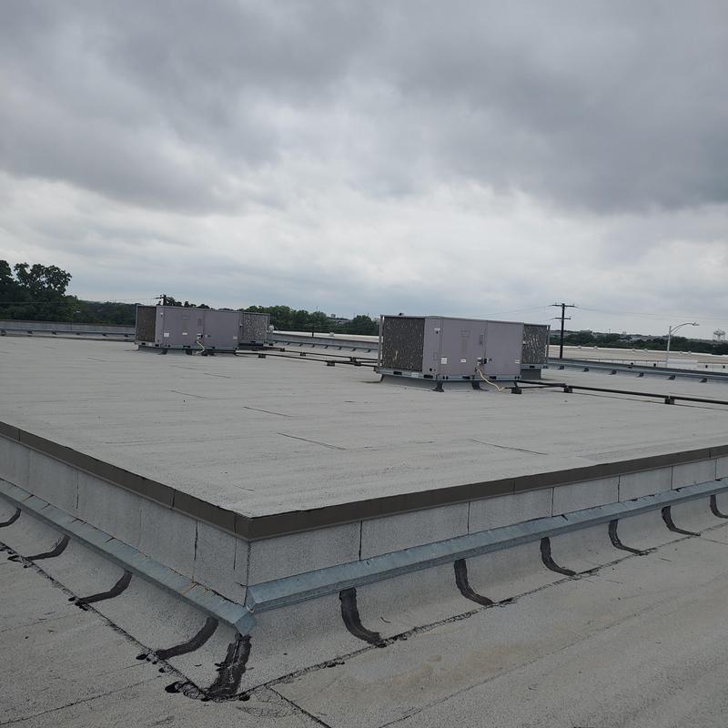 Commercial flat roof with HVAC units after hail damage