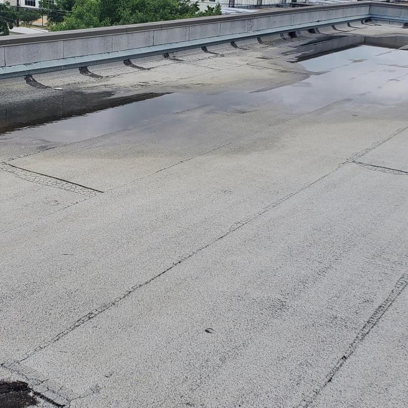 Flat roof surface with hail and wind damage