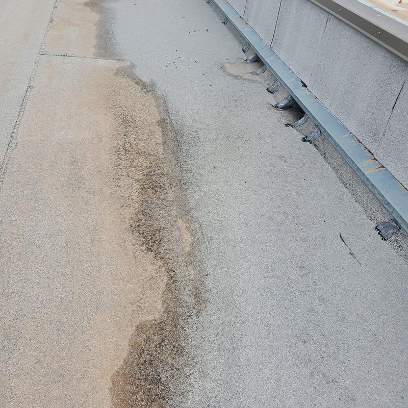 Flat roof membrane damage near parapet wall