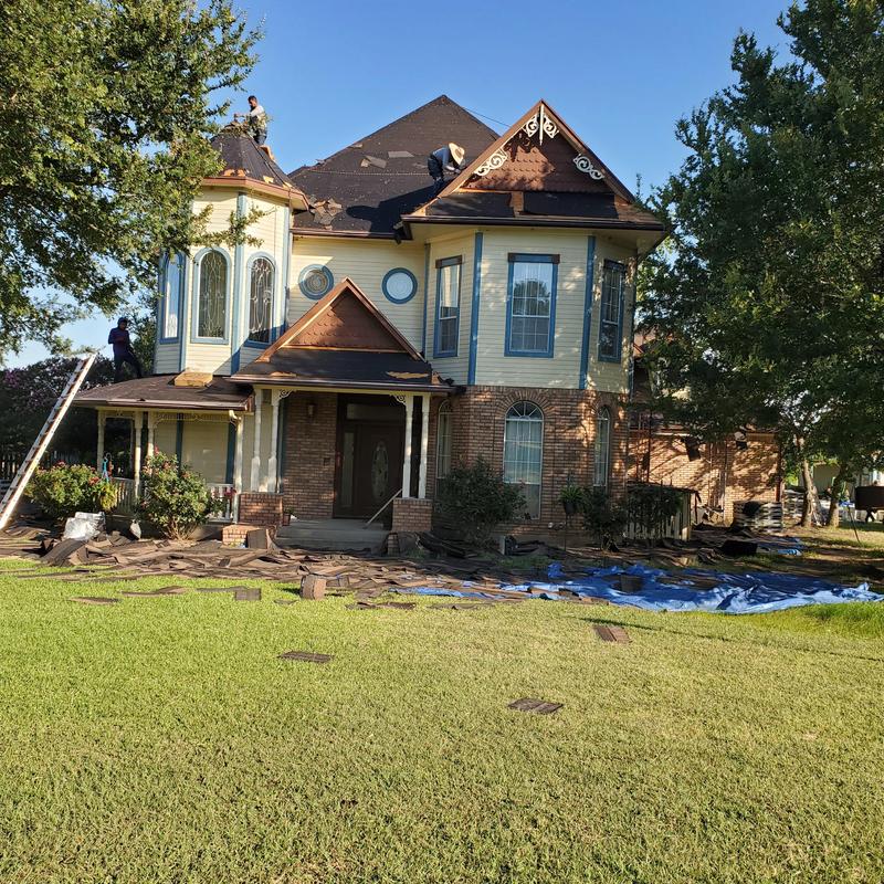 Asphalt shingle roof with hail damage repair in progress