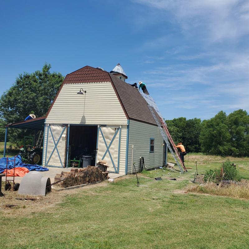 Roof shingles replacement on barn after hail damage