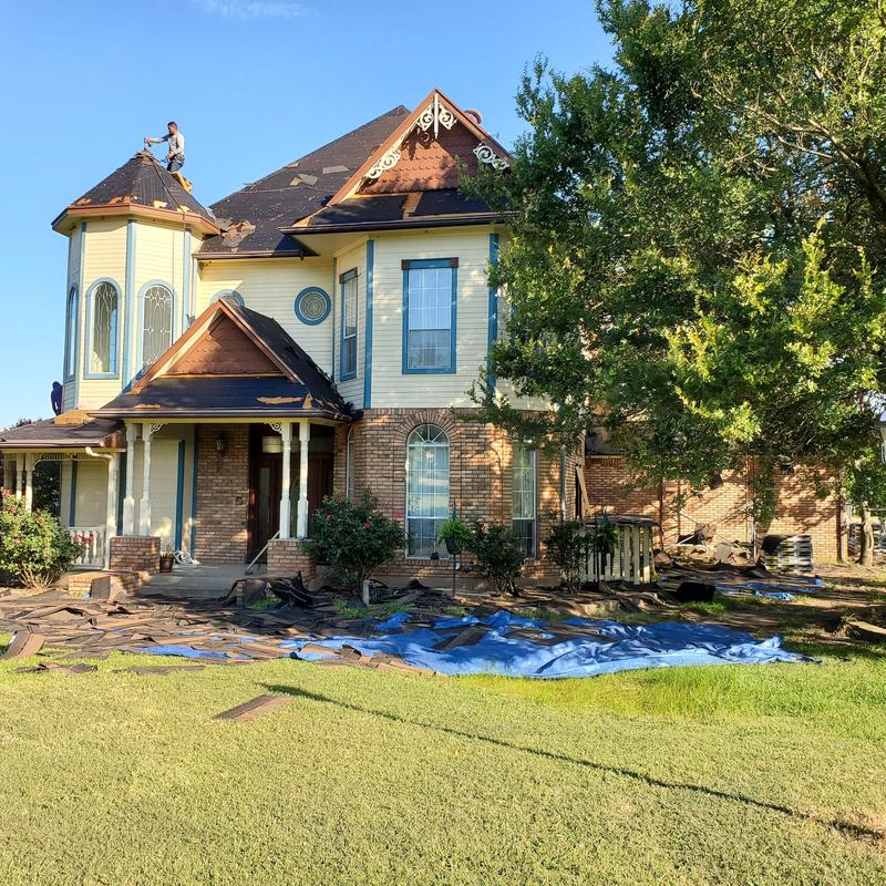Roof shingles hail damage with repair work in progress