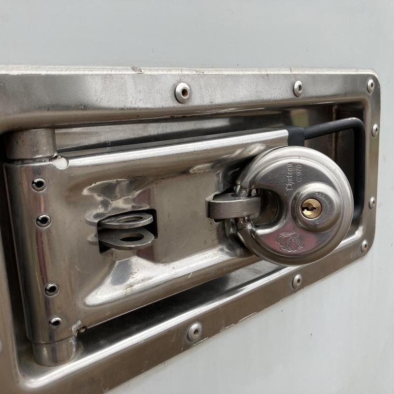 Storage container latch with disc padlock secured