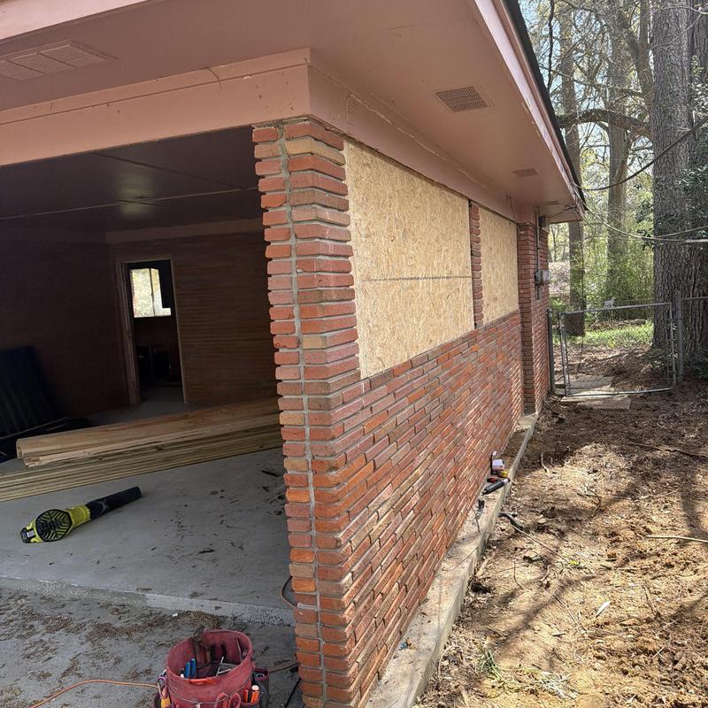 Garage exterior wall plywood installation with brick facade