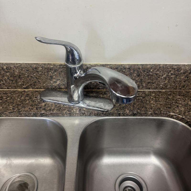 Kitchen faucet and dual stainless steel sinks with granite backsplash