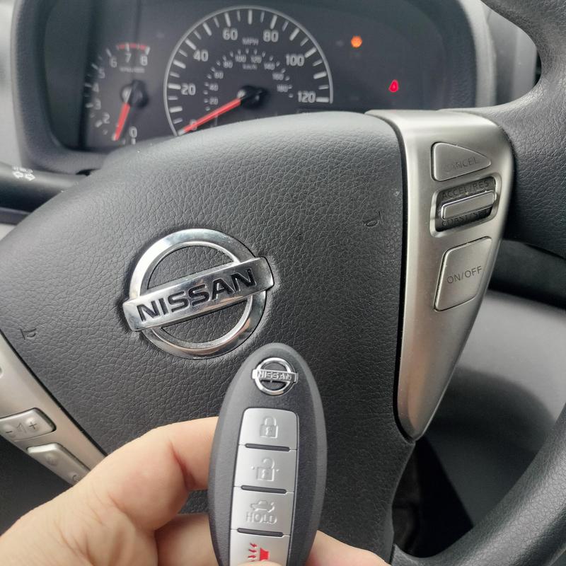 Nissan Altima key fob with steering wheel background