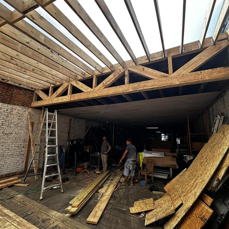 Wooden roof trusses framing with construction work in progress Wooden roof trusses framing with construction work in progress