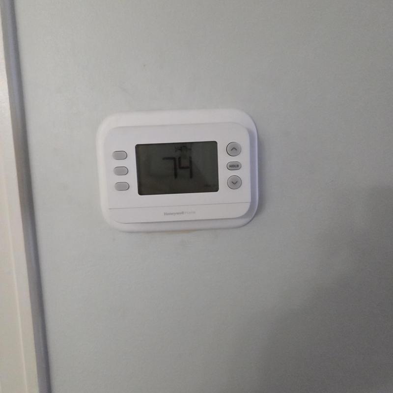 Honeywell thermostat displaying 74 degrees on wall