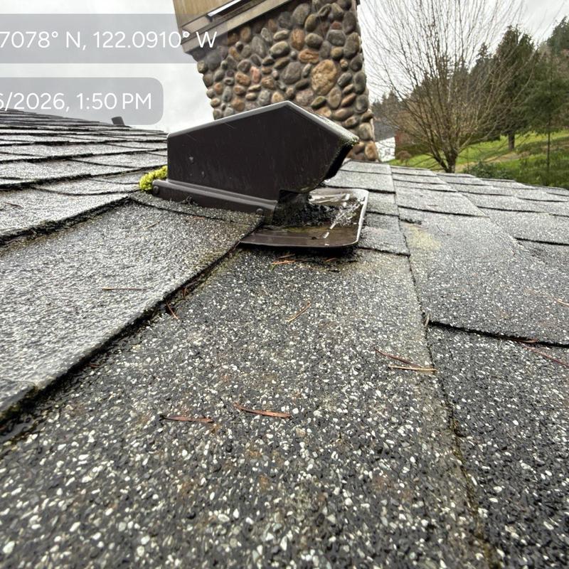 Roof vent flashing with wear and moss buildup on shingles