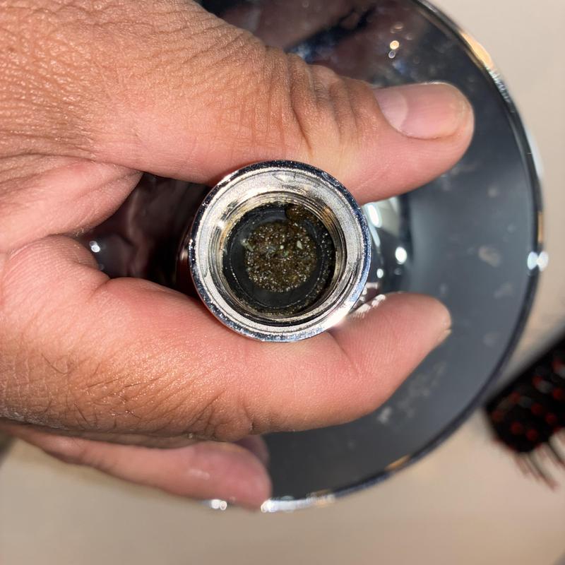 Shower head with debris buildup inside for cleaning