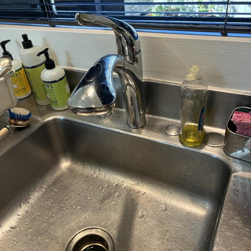 Kitchen faucet sprayer head with soap bottle nearby