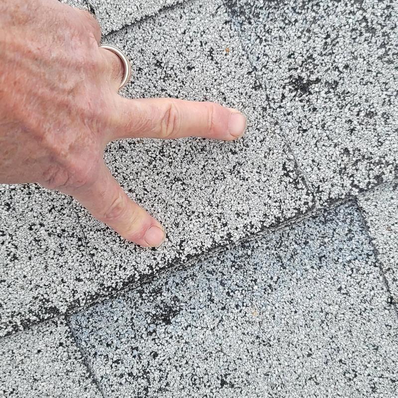Asphalt roofing shingles with hail impact detail