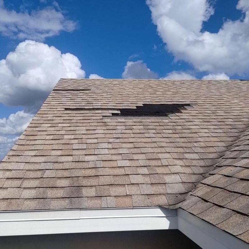 Asphalt shingle roof with damaged missing shingles