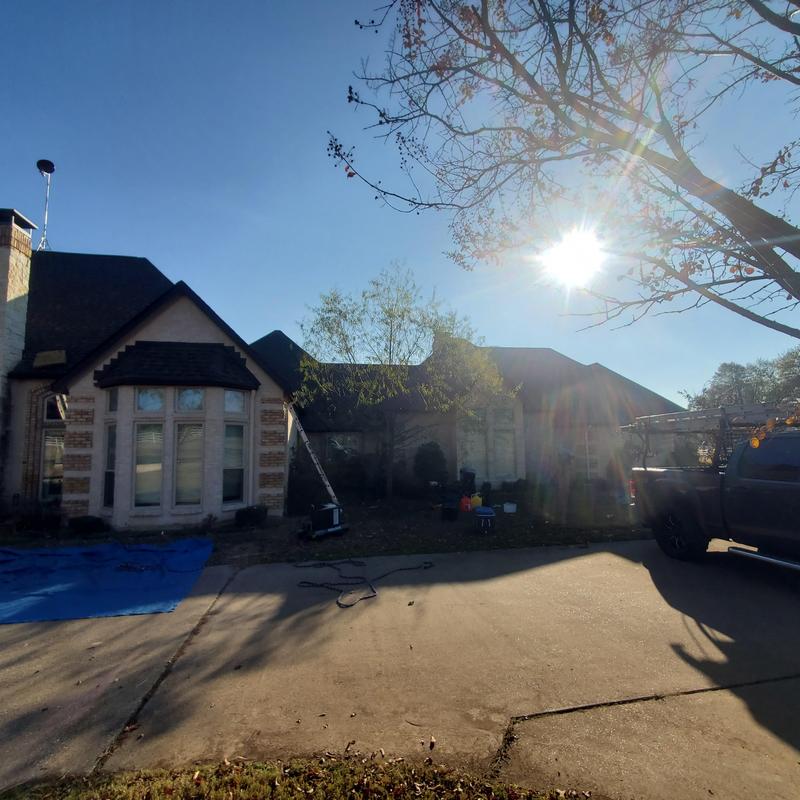 Roof shingles inspection with ladder and truck in driveway