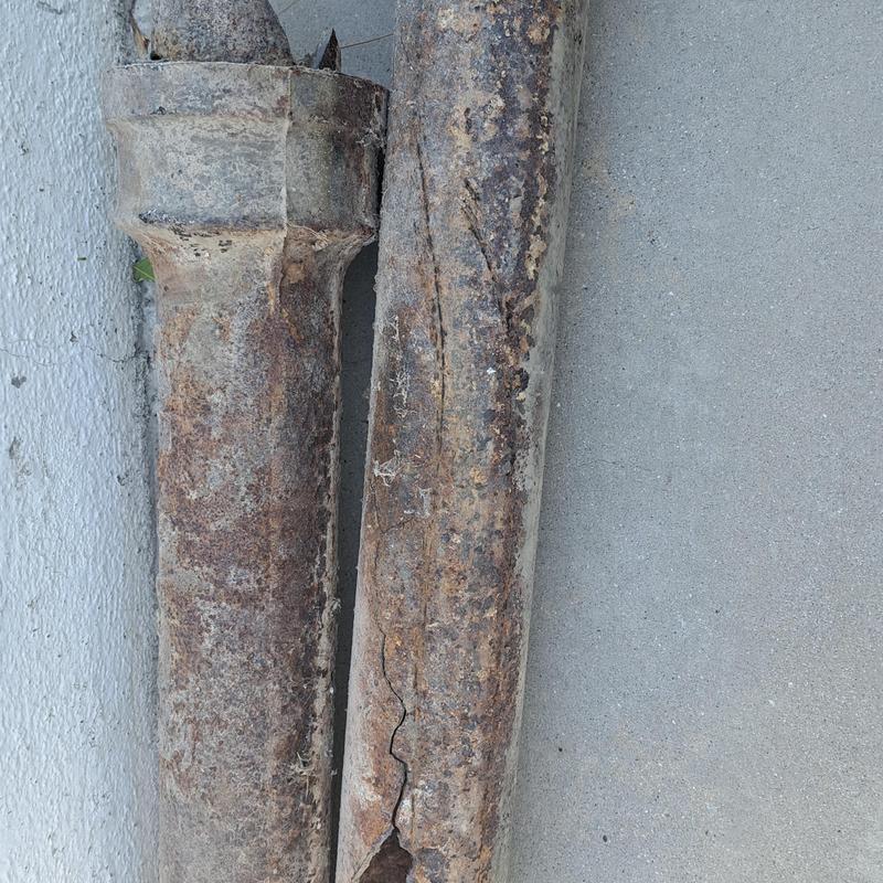 Cracked rusty cast iron sewer pipe sections removed