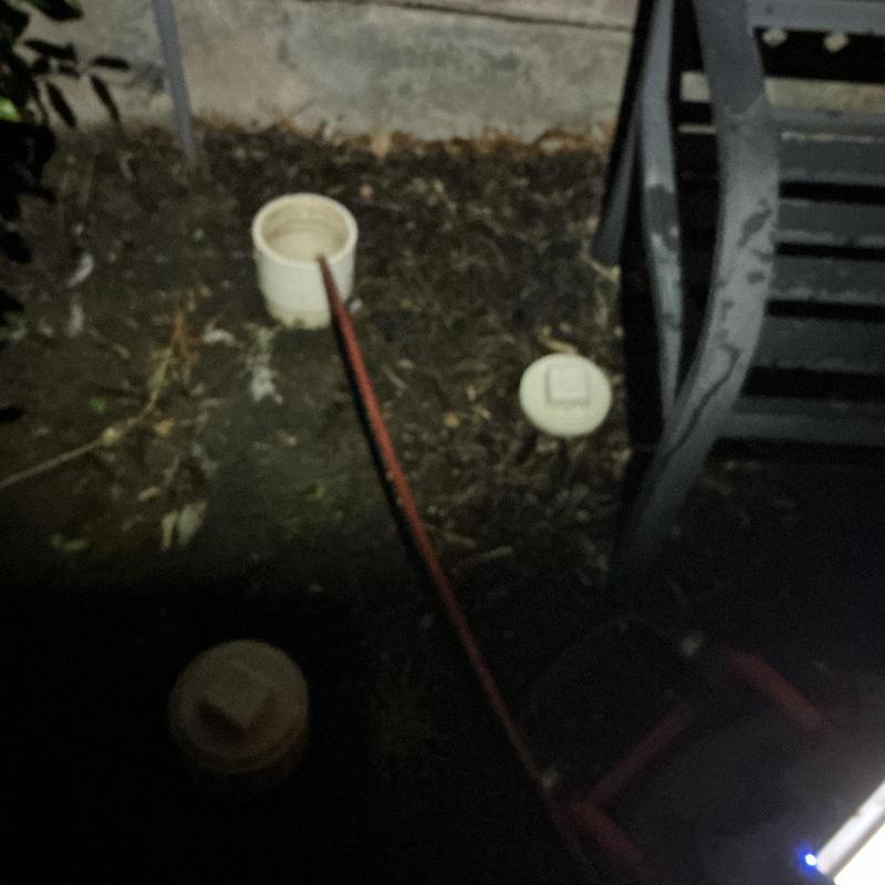 Drain cleanout with cable and inspection camera at night