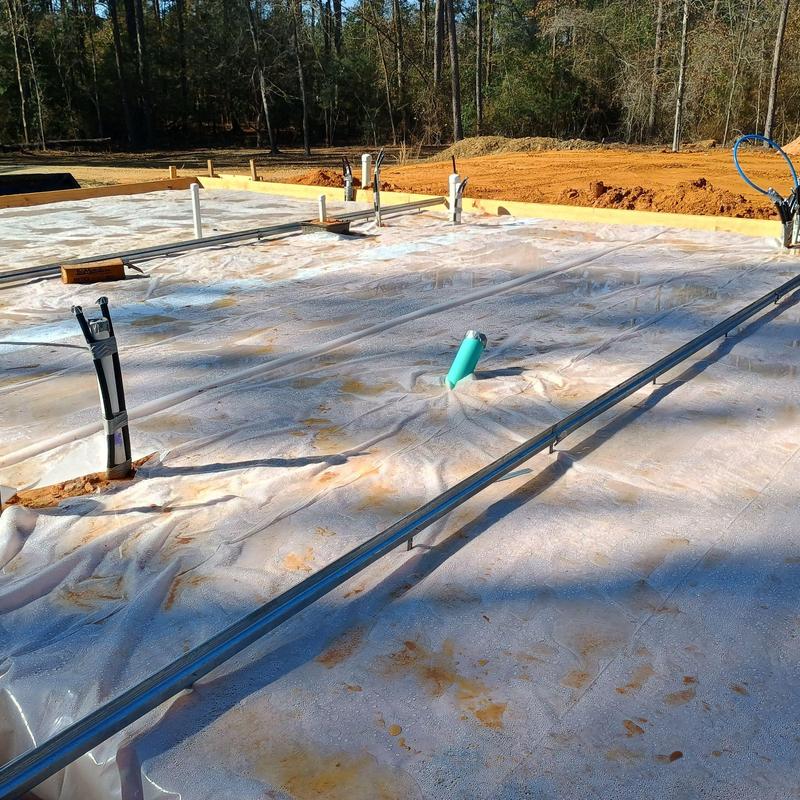 Concrete slab foundation with plumbing pipes and conduit