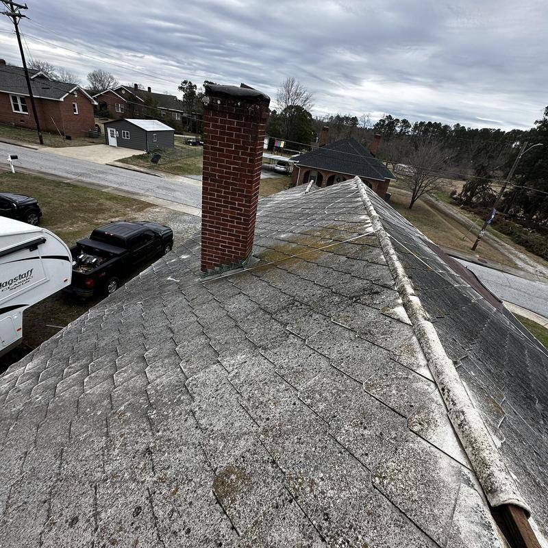 Asbestos shingle roof with chimney, showing wear Asbestos shingle roof with chimney, showing wear