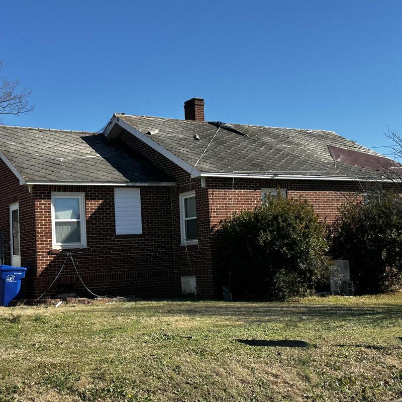 Asbestos shingle roof with damaged sections on brick house Asbestos shingle roof with damaged sections on brick house