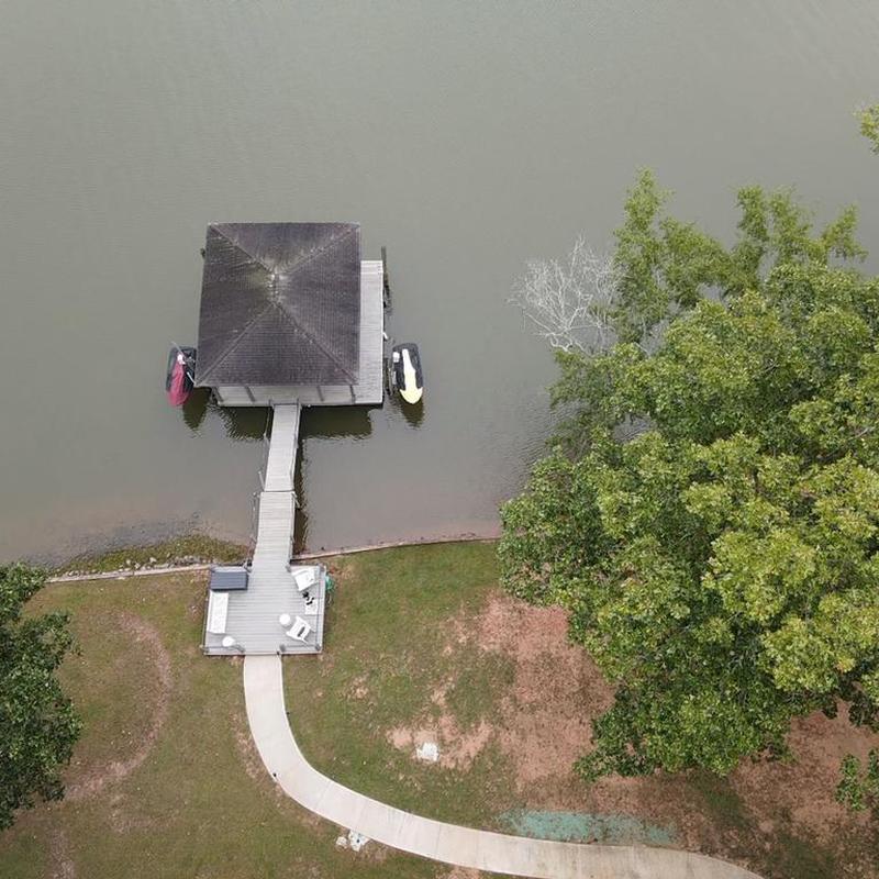 Lake dock with covered roof and kayaks at water's edge