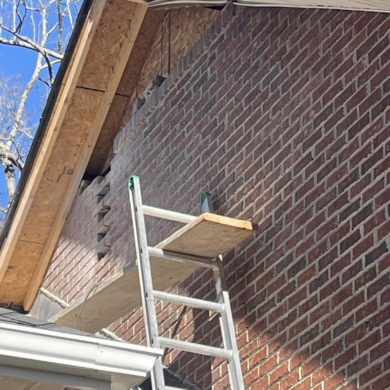 Brick masonry wall with scaffolding and roof fascia Brick masonry wall with scaffolding and roof fascia