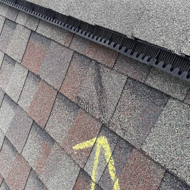 Asphalt shingles with hail damage marked for repair