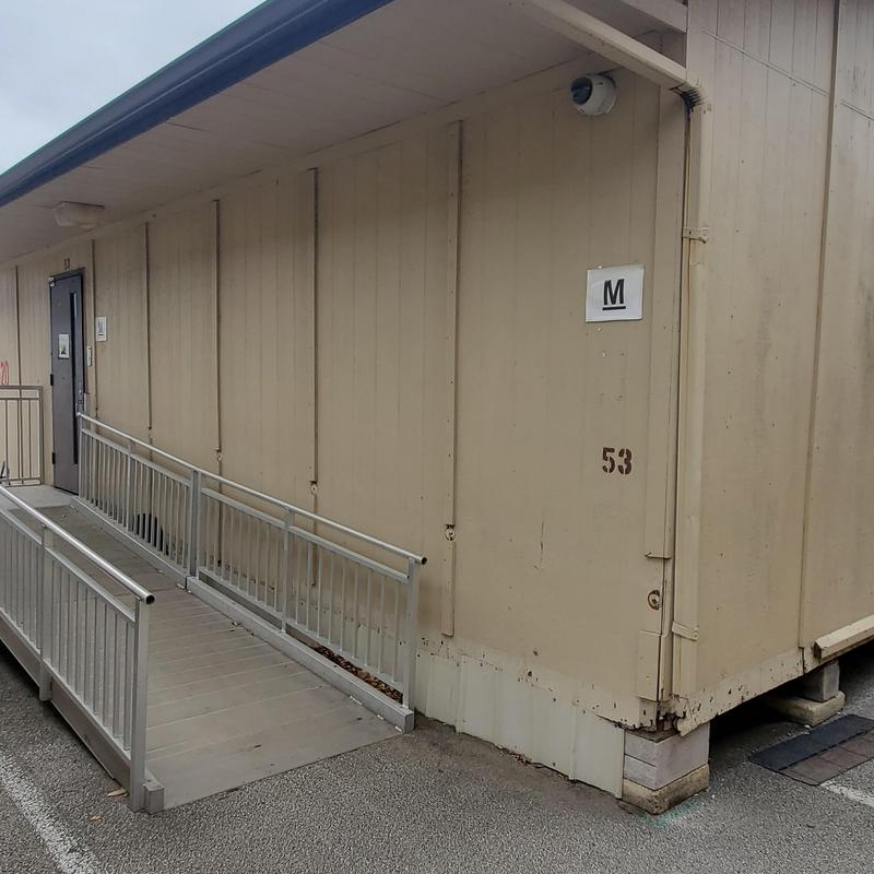 Building exterior siding with hail damage near ramp