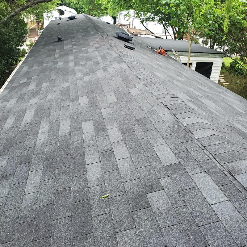 Asphalt shingle roof with storm damage and repairs