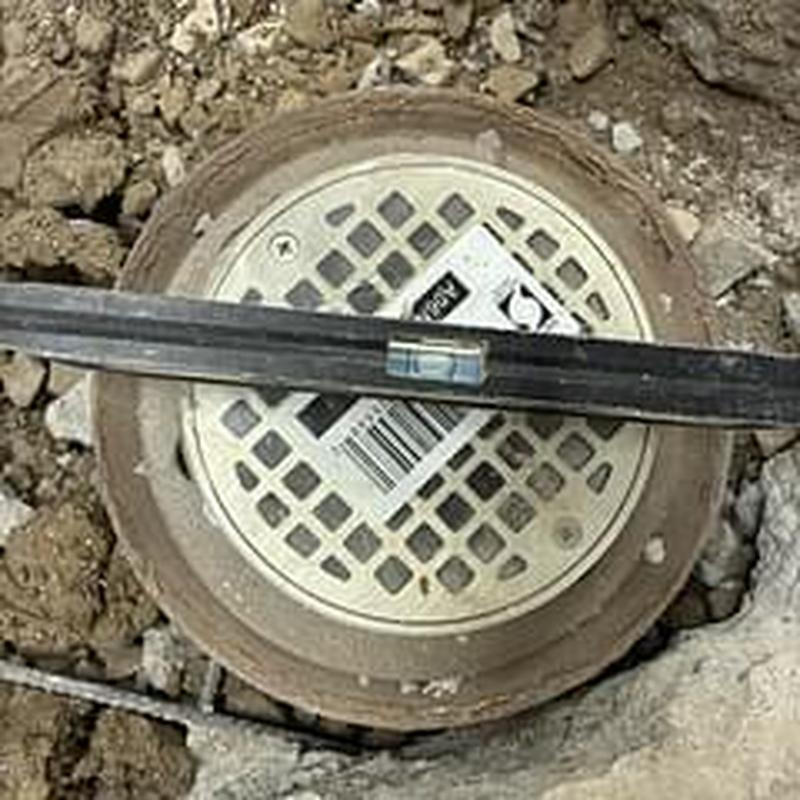 Floor drain with level tool on construction site
