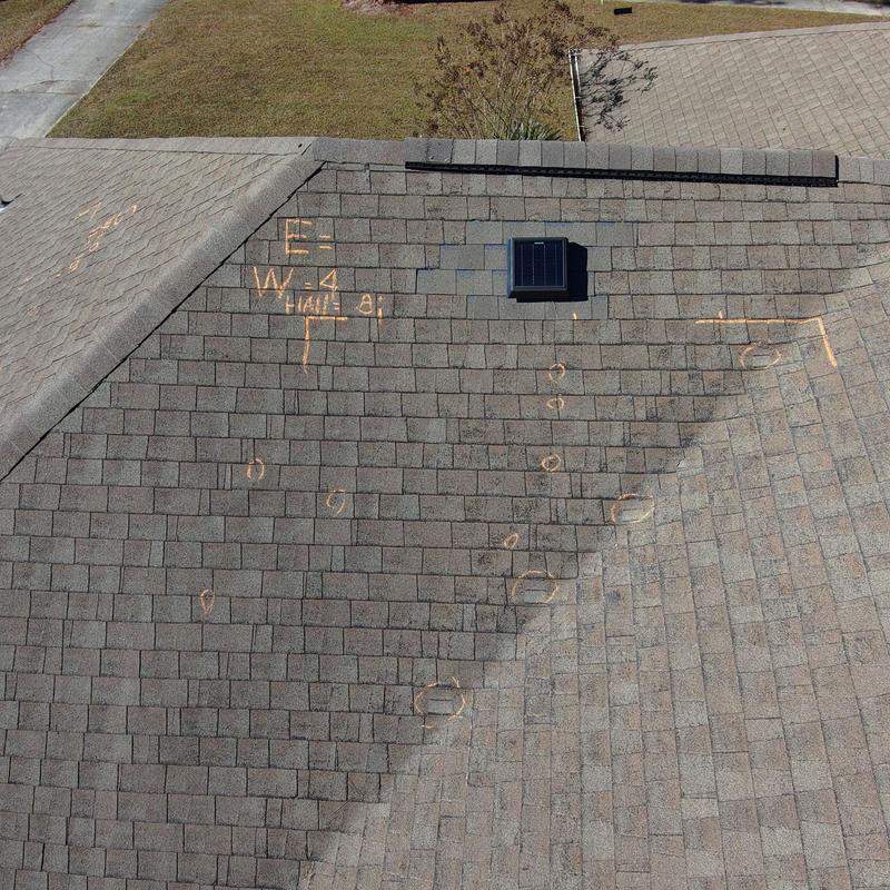 Asphalt shingle roof with hail damage markings and vent