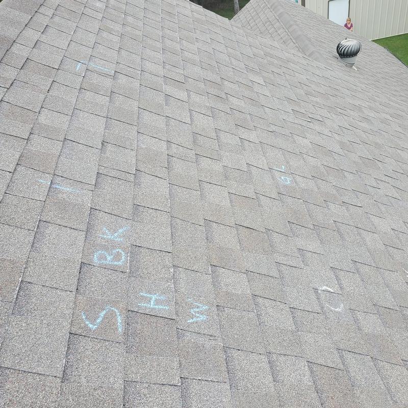 Asphalt shingle roof with hail damage markings and vent