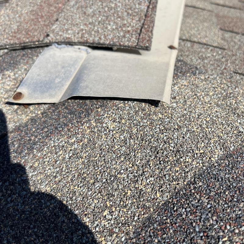 Roof flashing with lifted shingle and exposed nailhead Roof flashing with lifted shingle and exposed nailhead