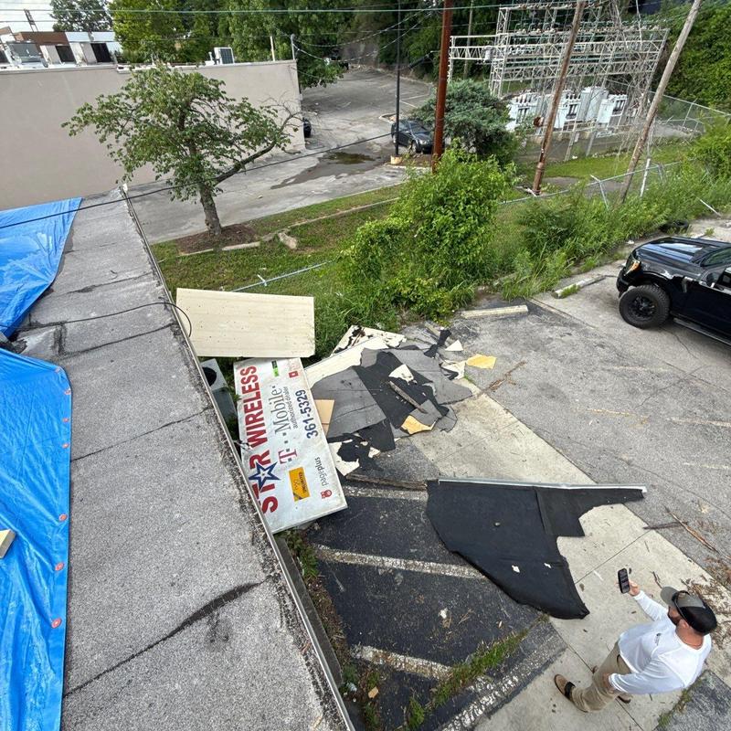 Asphalt shingle roof debris and tarp cover after damage