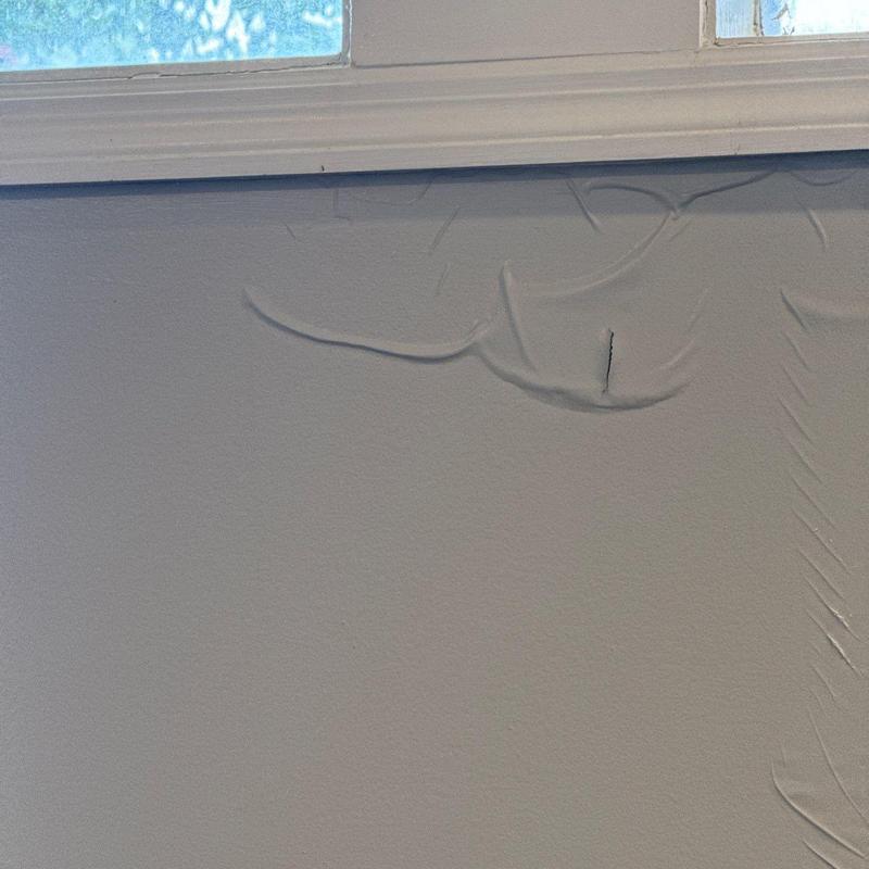 Drywall surface with bulging and cracking near window trim