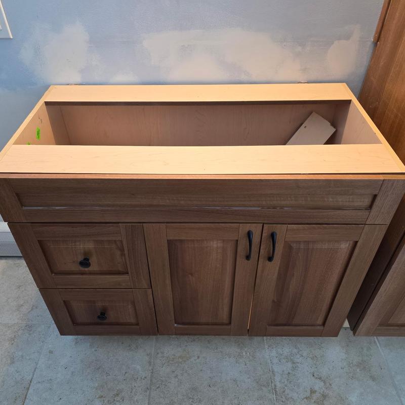 Vanity cabinet installed after rough plumbing in bathroom