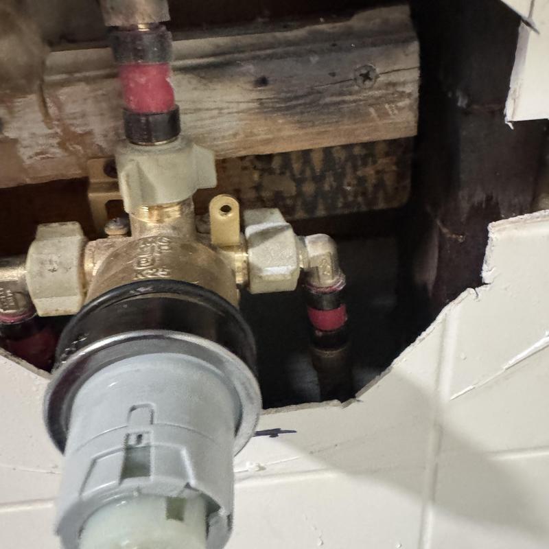 Shower valve with connected plumbing pipes inside wall cavity
