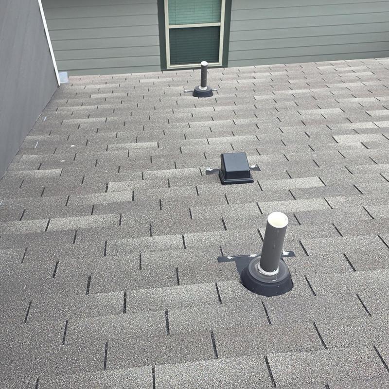 Asphalt shingle roof with ventilation pipe flashing after hailstorm