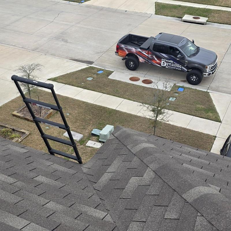Asphalt shingle roof with inspection ladder and truck nearby