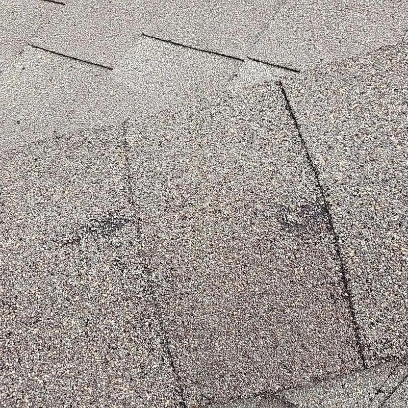 Asphalt shingles with visible hail damage close-up Asphalt shingles with visible hail damage close-up